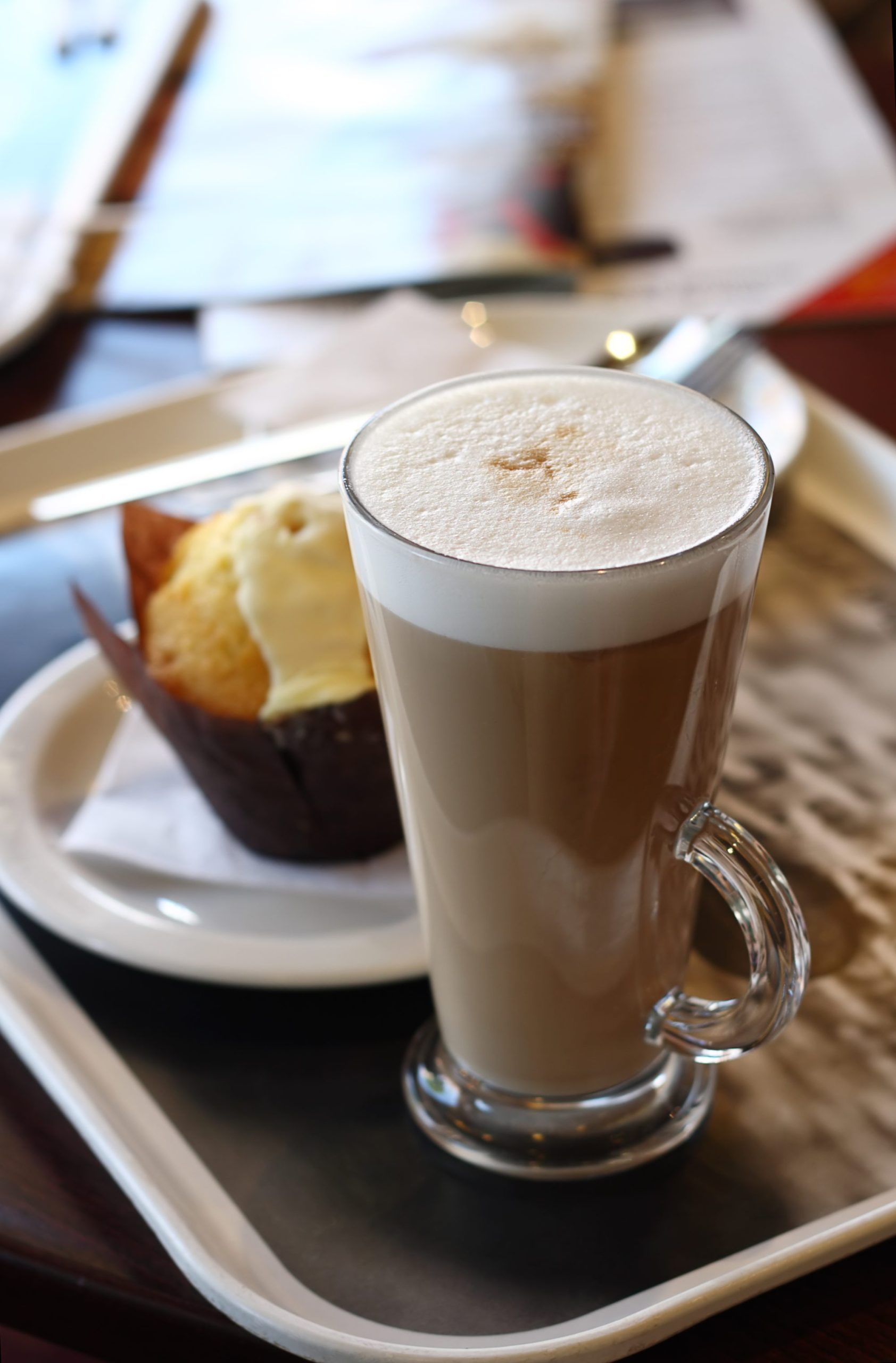 Cafe coffee - Latte in a glass with lemon muffin in background